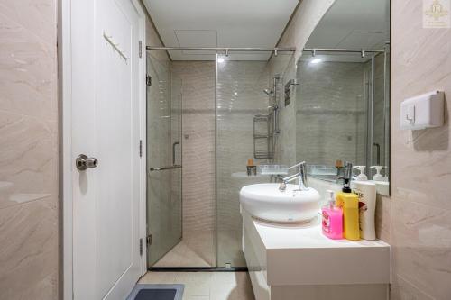 a bathroom with a shower and a sink and a toilet at Landmark Plus Vinhomes CityView Suite in Ho Chi Minh City