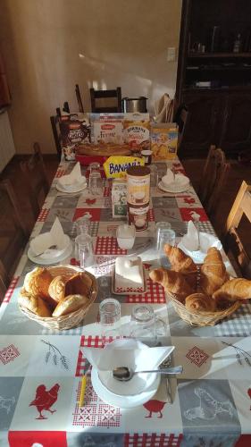 a table with baskets of bread and other food on it at Goutanou chambre 3 in Châtillon-en-Michaille