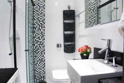 uma casa de banho com um WC, um lavatório e um chuveiro em Flat Hilário no Rio de Janeiro