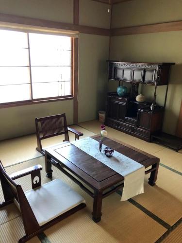 a living room with a wooden table and chairs at 小樽祝津山荘1号楼 in Otaru