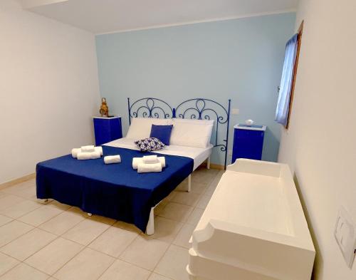 a bedroom with a blue and white bed and a bench at MARECHIARA Apartment - Independent ground-floor unit in central Nettuno with private patio, just 50 m from the sea and steps from the train station in Nettuno