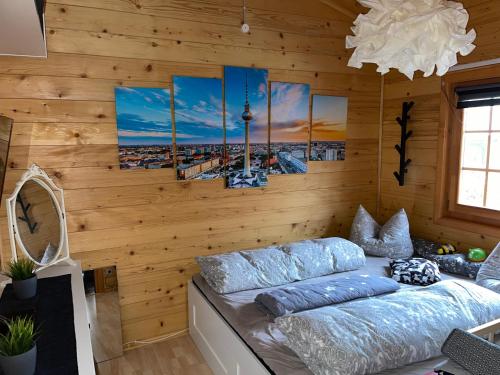 a room with wooden walls and a bed with blue pillows at Bergzauber Hütte in Langelsheim