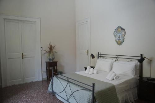 a bedroom with a bed with white sheets and white pillows at Maison Canopée in Messina