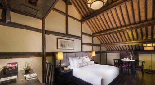 a bedroom with a large white bed and a table at Hotel Dayu Kaiyuan in Shaoxing