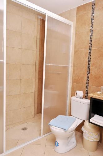 a bathroom with a toilet and a shower at Hotel de las Américas - Ambato in Ambato
