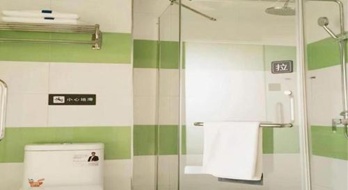 a bathroom with green and white striped walls and a toilet at 7 Days Inn Hami Baofeng Market in Qumul
