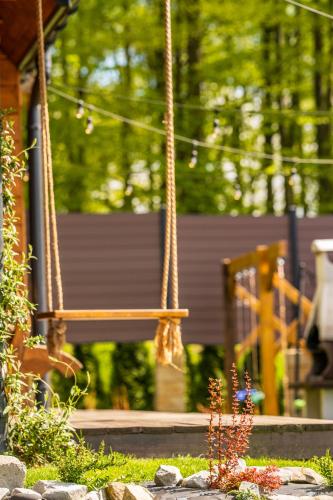 a swing in front of a house with a garden at Bieszczadzka Hawira - w Centrum przy Jeziorze z Widokiem dla Rodzin in Polańczyk