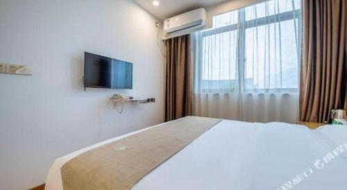 a hotel room with a large bed and a window at GreenTree Inn Huayin Huashan Town Huashan Scenicspot Express Hotel in Huayin