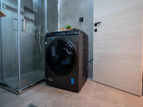 a washing machine in a bathroom next to a shower at Canva Living in Xanthi