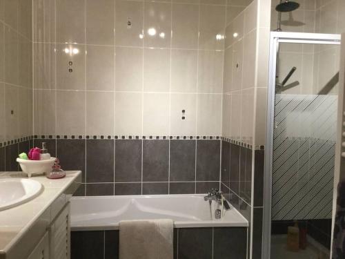 a bathroom with a bath tub and a sink at hébergements proche pole européen du cheval et du circuit des 24h in Yvré-lʼÉvêque