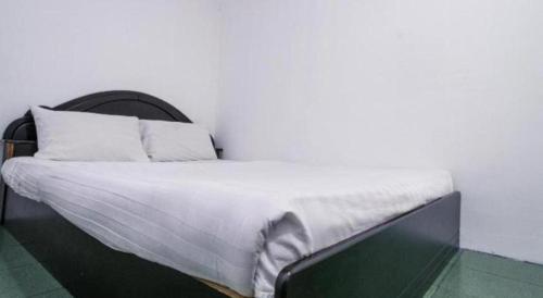 a bed with white sheets and pillows in a room at OYO 89706 To-day Hotel in Sibu