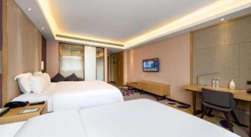 a hotel room with two beds and a desk at Lavande Hotels· Guizhou Anshun Xi Railway Station in Anshun