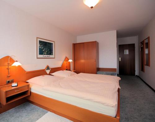 a bedroom with a large bed with a wooden headboard at Zum Alten Brauhaus in Hofgeismar