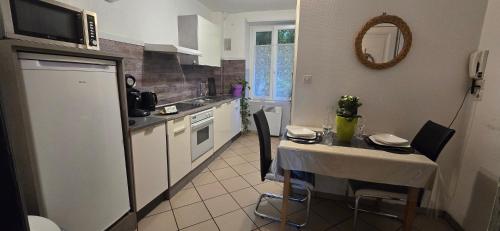 cocina con mesa pequeña y cocina con microondas en Appartement avec jardin à Colmar, en Colmar
