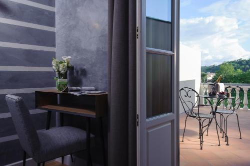 a room with a balcony with a table and chairs at Hotel Lungarno Vespucci 50 in Florence