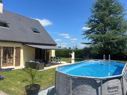 une piscine dans une cour à côté d'une maison dans l'établissement Villa Rose, à Graignes