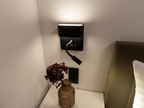 a vase with a plant on a table next to a wall at Canva Living in Xanthi