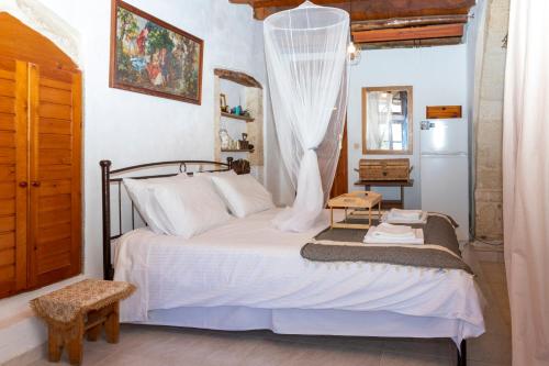 a bedroom with a bed with a curtain over it at Villa Folia - PassiveinCreteBns in Maroulás