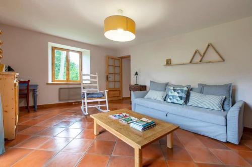 un salon avec un canapé bleu et une table basse dans l'établissement La Bergerie apartment in an old farmhouse!, à Nâves-Parmelan