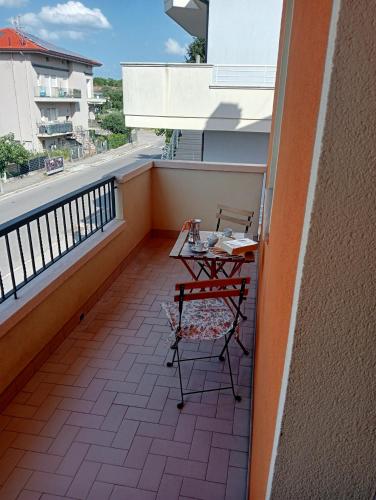 a small balcony with a table and chairs on it at La tua Casa al mare in Cattolica