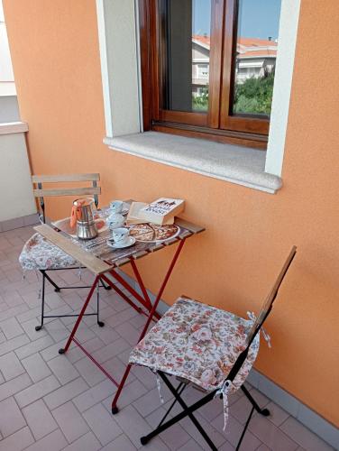 a table and a chair and a table and a window at La tua Casa al mare in Cattolica