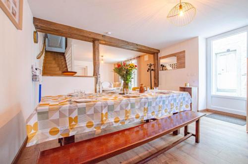 a dining room with a long table with a table cloth at Chez gillou in Jaucourt