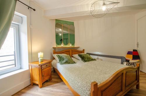 a bedroom with a bed and a mirror and a window at Chez gillou in Jaucourt