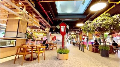 a restaurant with tables and chairs and people sitting at tables at Tokyo Riverside PIK 2 by Kakarama Room in Muara