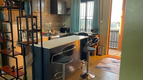 a kitchen with a counter and some stools in it at Kigo Close Apartments in Kigo