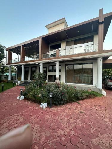 Un gran edificio con un patio de ladrillos rojos en el frente. en Nivāsā By Purva, en Zadapoli