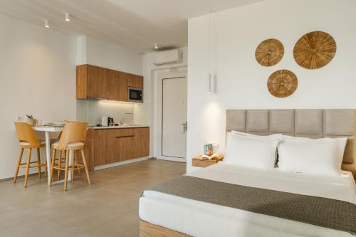 a bedroom with a large bed and a kitchen at Ninemia Luxury Residence in Perdika