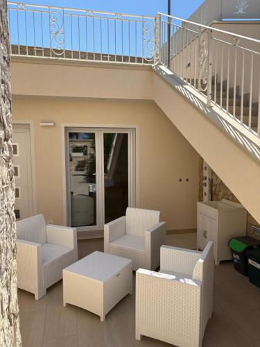 a balcony with white furniture and a staircase at Salento Appartamento Stella in Marina di Mancaversa