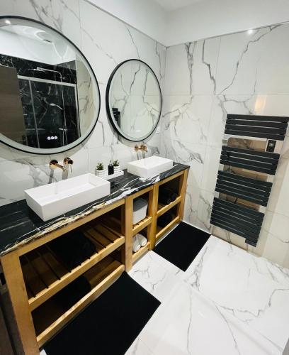 une salle de bain avec deux lavabos et un miroir dans l'établissement Grand gîte en pleine nature, à Domme