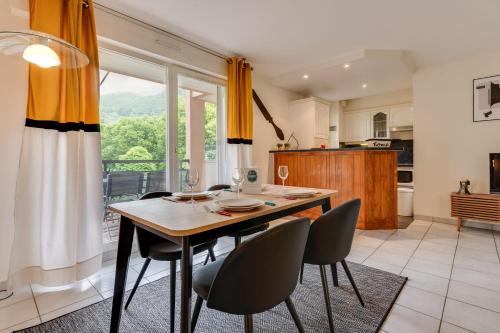 une salle à manger avec une table et des chaises et une fenêtre dans l'établissement Le Parc des Raisses - T2 pouvant accueillir 4 personnes, à Annecy