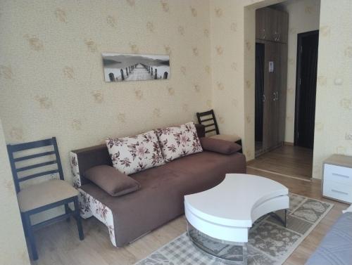 a living room with a couch and a table at Къща за гости АКАЦИЯ in Ravna Gora