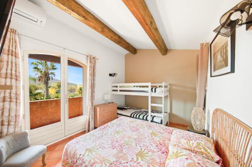 une chambre avec un lit et une fenêtre dans l'établissement LE MAS CECYLAE, à Carqueiranne