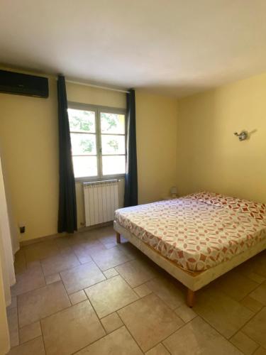 une chambre avec un lit et une fenêtre dans l'établissement Tranquillité et authenticité dans les hauteurs, à Le Tignet