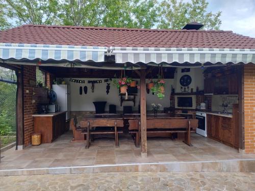 a patio with a table and a kitchen at Къща за гости АКАЦИЯ in Ravna Gora