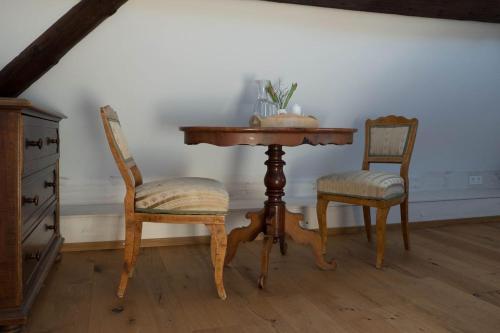 a wooden table and two chairs and a table and chairs at Kulturvogtei Freiburg-Tiengen in Freiburg im Breisgau
