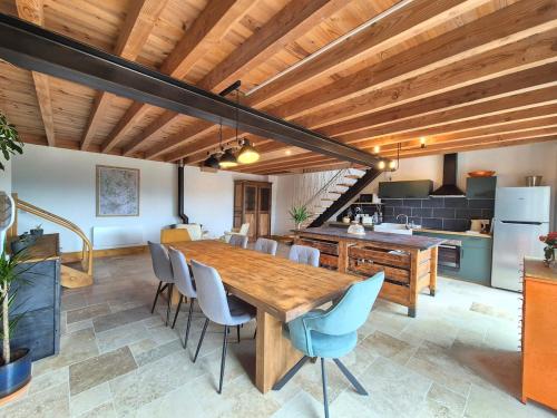 une cuisine et une salle à manger avec une table et des chaises en bois dans l'établissement Chez Bob - Grange de Charme, à Olloix