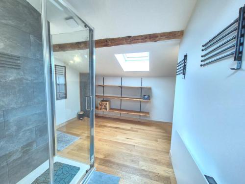ein Bad mit einer Glasdusche im Zimmer in der Unterkunft Chez Bob - Grange de Charme in Olloix