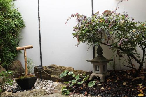 a garden with a bird bath and a tree at Shizuka Ryokan Japanese Country Spa & Wellness Retreat in Hepburn Springs
