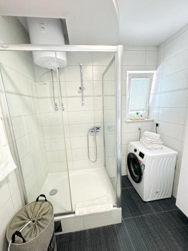a bathroom with a shower and a washing machine at Apartments LUPE in Split