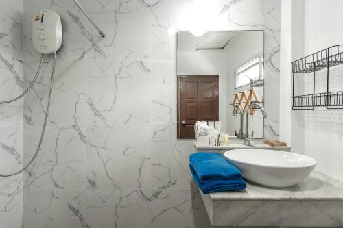 ein Badezimmer mit einem weißen Waschbecken und einem Spiegel in der Unterkunft V205 Island Hideaway Near Promthep Sunset in Nai Harn Beach