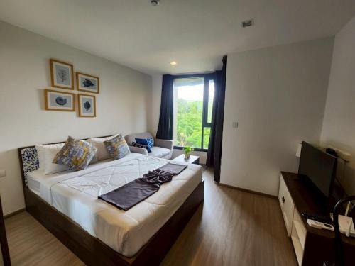 a bedroom with a large bed and a television at The Base Central Phuket-B32YJ in Ban Rangeng