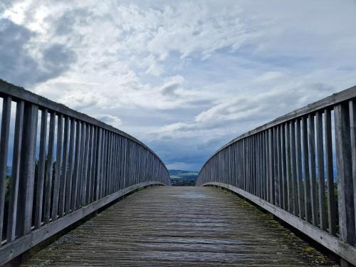 a wooden bridge with a cloudy sky in the background at Failte Stay in Inverness