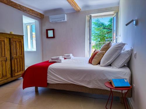 une chambre avec un grand lit avec une fenêtre dans l'établissement La Magnanerie 1818 Luberon proche Gordes, Roussillon, à Saint-Saturnin-lès-Apt