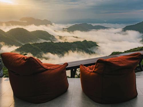 Ban Huai PhaiPino Latte Khao Kho的坐在山顶上的沙发，欣赏美景