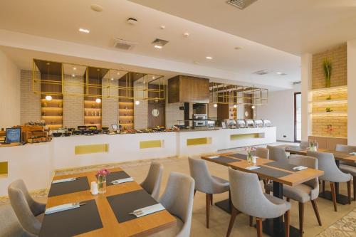 a restaurant with tables and chairs and a kitchen at Radisson Resort Ruza Vjetrova in Dobra Voda