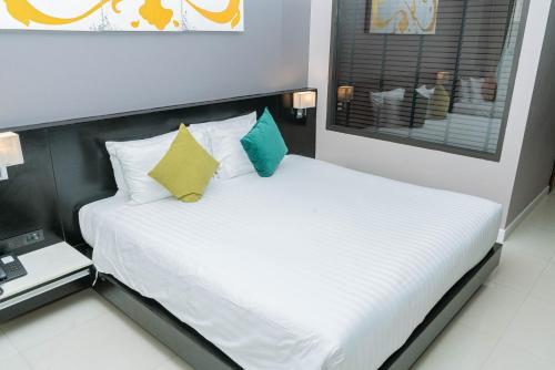 a bedroom with a white bed with a black headboard at Beachfront and Deluxe Pool Access Patong Phuket in Patong Beach